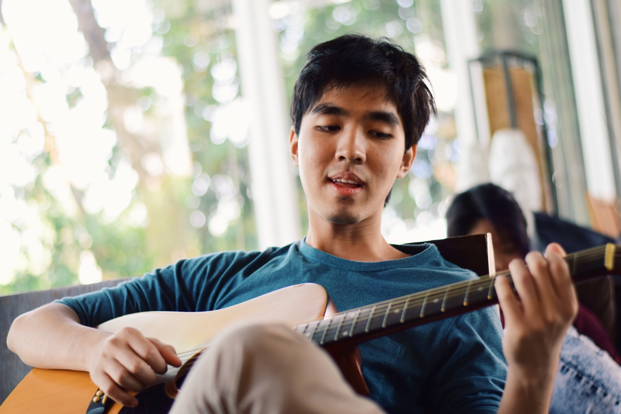 Young man playing the guitar inside