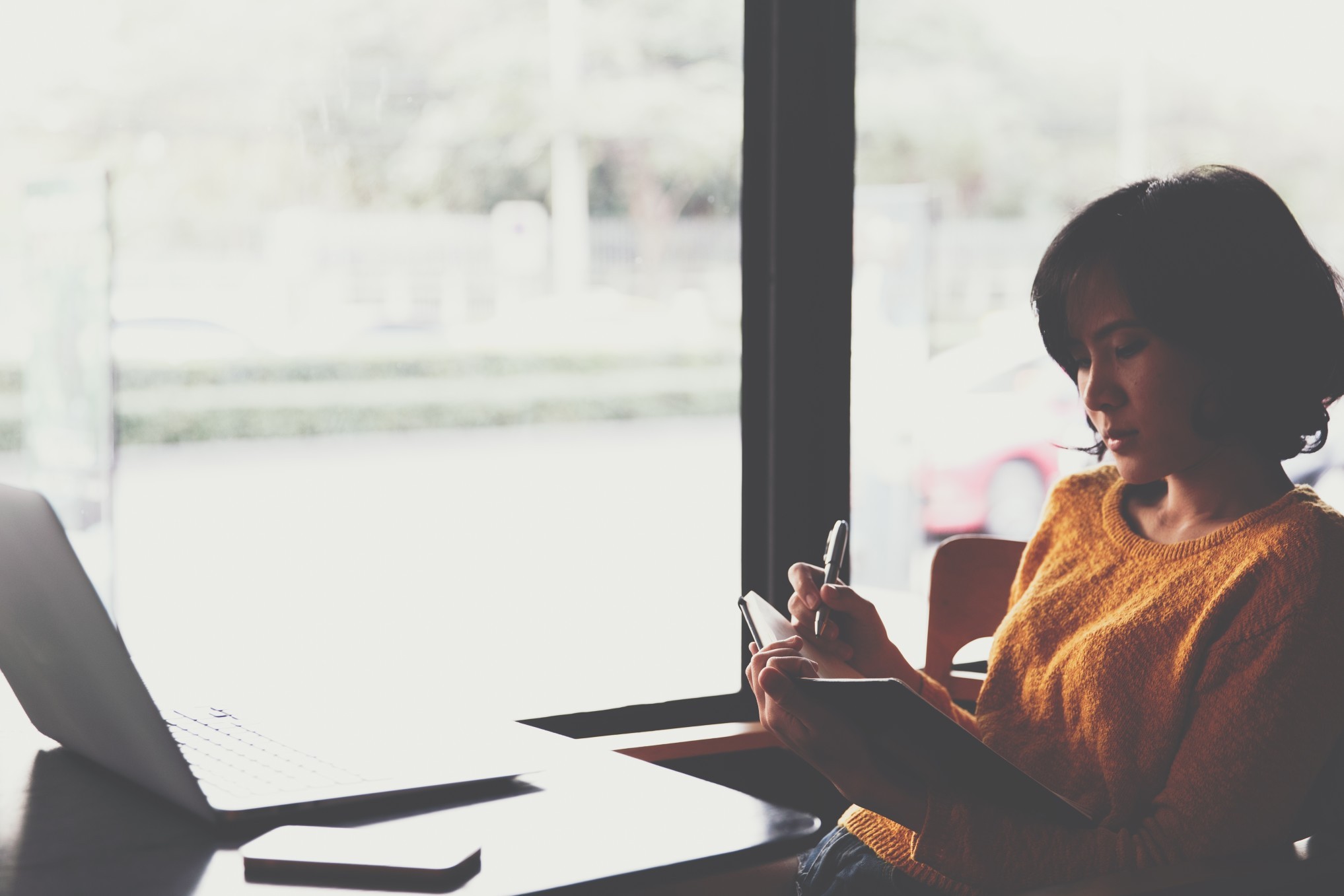 A hipster asian woman working with laptop and writing information into notebook background writing t20 v Kn JAE
