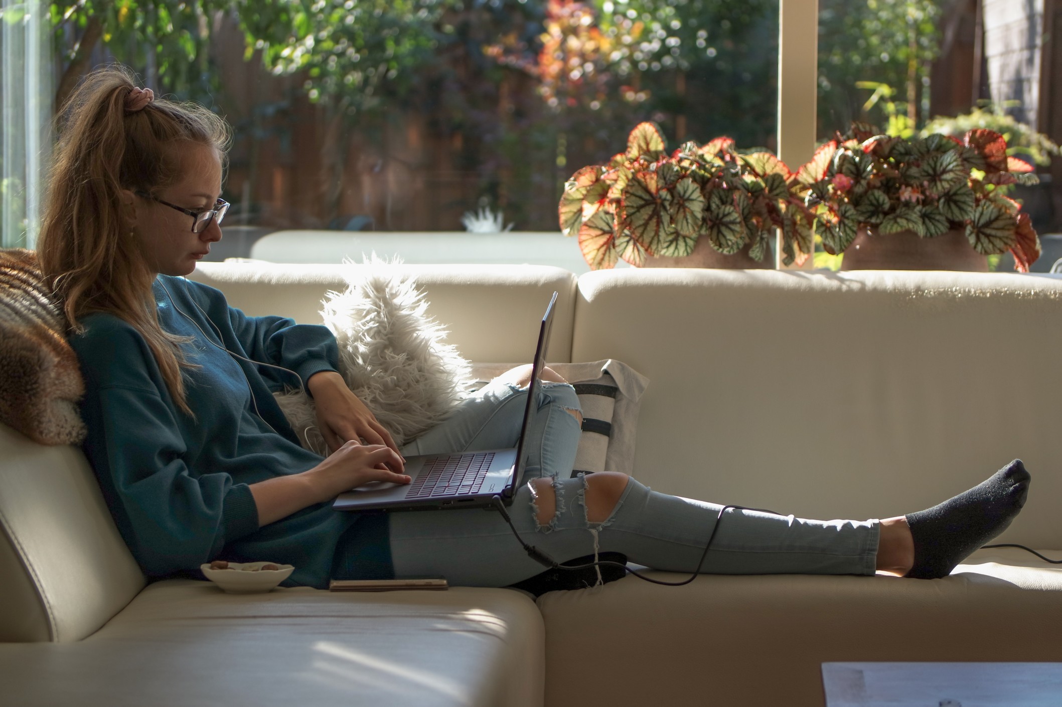 Girl sitting on the white couch and using laptop t20 ko Yl QP