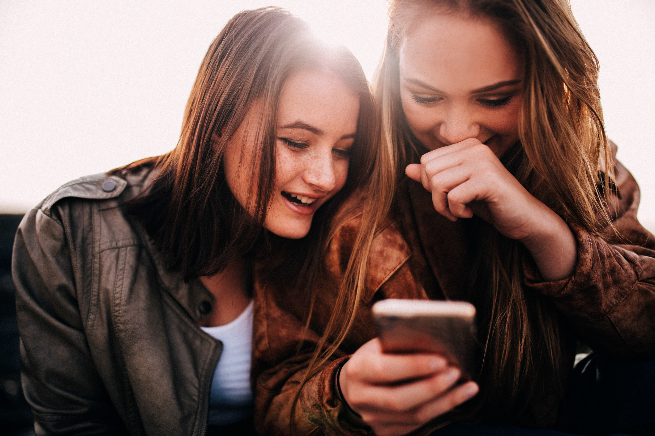 Teenage girls looking at funny photos on smartphone and laughing t20 g8 VN Kb